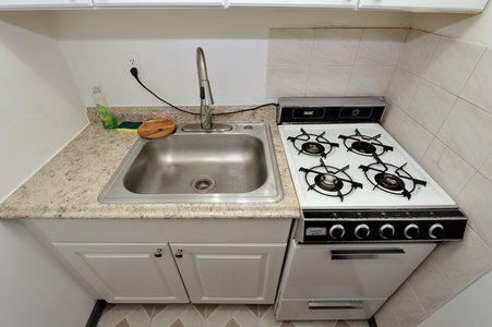 Your compact kitchenette features a gas stove and sink, perfect for preparing simple meals during your stay.