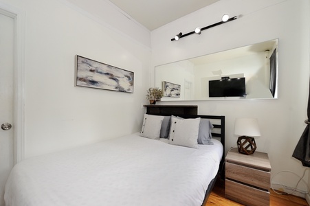 Unwind in your thoughtfully designed bedroom featuring crisp linens, modern art, and a mounted TV for cozy evenings in.