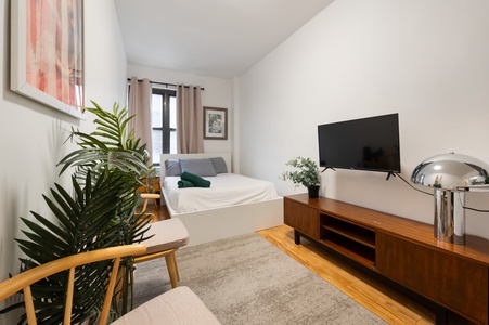 Unwind in your stylish living room with warm wood tones, lush greenery, and modern touches that create the perfect home-away-from-home atmosphere.