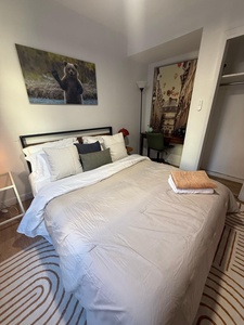 Sink into crisp white linens and admire charming artwork while your wardrobe stays organized in the spacious closet nearby.