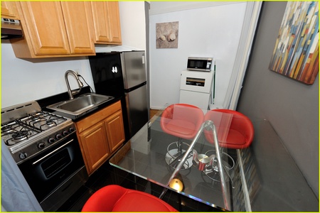 Your sleek kitchen features modern appliances and a glass dining table where you can enjoy meals together in style.