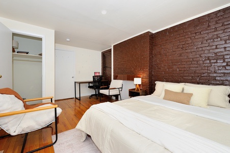 Sink into crisp white linens against stunning exposed brick walls, with your own workspace and cozy reading chair.
