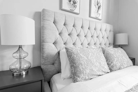Sink into the plush tufted headboard as soft bedding and elegant nightstand lamps create your perfect sanctuary.