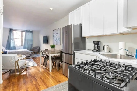 Your spacious studio features a gleaming modern kitchen with stainless steel appliances and gas stove, perfect for cooking together.