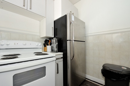 Your fully equipped kitchen has everything you need - stainless steel fridge, oven, stove, and thoughtful touches like cutlery and cooking essentials ready for your stay.