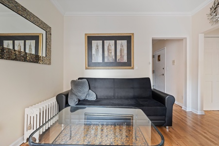 Unwind on your sleek sofa in this modern living space with polished hardwood floors and elegant artwork.