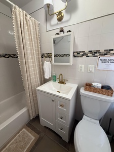 Your private bathroom features modern touches with a spacious vanity, brass fixtures, and thoughtful amenities for your comfort.