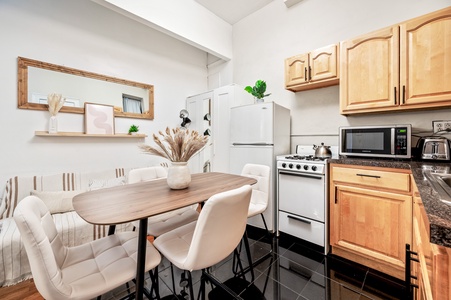 Your stylish kitchen invites cozy meals with warm wood cabinetry, modern appliances, and a perfect dining nook for morning coffee or evening conversations.