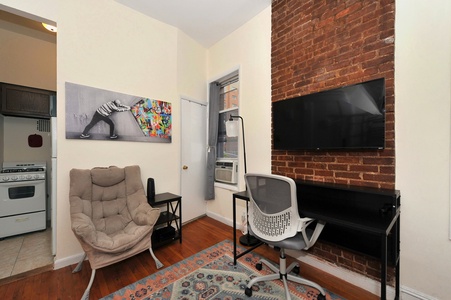 Your cozy living space features exposed brick walls, comfortable seating, and modern amenities for relaxation after exploring the city.