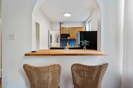 Your breakfast bar invites cozy morning coffee with warm wood counters and woven seating overlooking the fully-equipped kitchen.