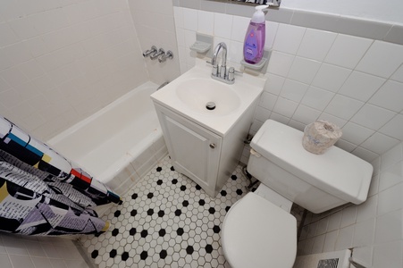 Your bright bathroom features everything you need: a deep soaking tub, vanity sink, and classic hexagon tile floors for that perfect vintage charm.