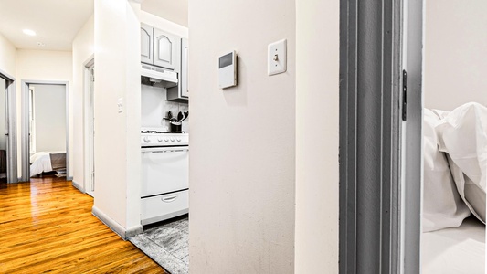 Your stylish space features a modern kitchen with sleek white appliances and warm hardwood floors that flow throughout your comfortable home.