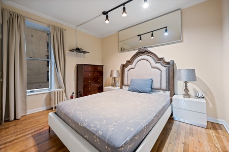 Sink into your plush bed with its elegant tufted headboard while warm track lighting creates a cozy ambiance for your evening wind-down.