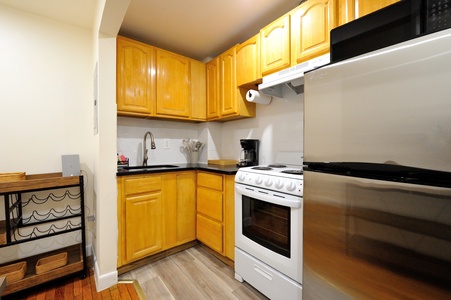 Your fully equipped kitchen awaits with warm wood cabinets, modern appliances, and everything needed for home-cooked meals during your stay.