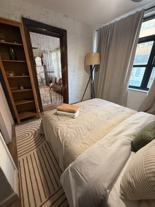 Sink into crisp linens and soft textures in your serene bedroom retreat, where natural light filters through flowing curtains.