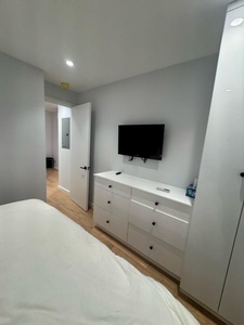 Your modern bedroom features sleek built-in storage and wall-mounted TV for comfortable entertainment after exploring the city.