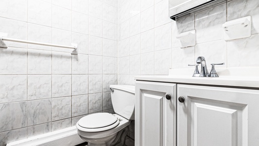 Fresh white marble tiles and elegant fixtures create your perfect private retreat, complete with plush towels ready for relaxation.