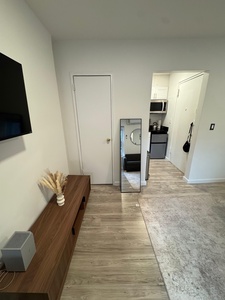 Your modern studio flows seamlessly from living to kitchen, with sleek wood finishes and everything you need for a comfortable stay.