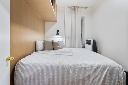 Unwind in your cozy bedroom with soft linens, modern wood accents, and convenient climate control for perfect comfort.