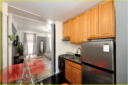 Your fully-equipped kitchen features warm wood cabinets, stainless steel appliances, and flows seamlessly into the cozy living space.