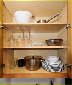 Your fully equipped kitchen cabinet holds everything you need for home cooking - quality cookware, dishes, and glassware await your culinary adventures.