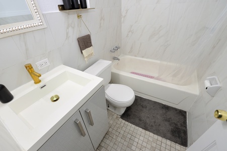 Unwind in your elegant marble bathroom with a deep soaking tub, perfect for luxurious bubble baths after exploring.