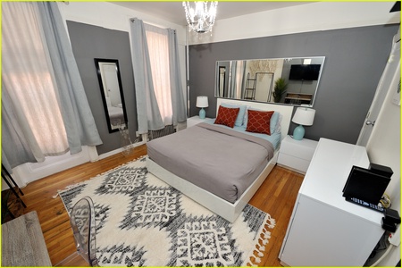 Sink into your stylish sanctuary with crisp linens, modern amenities, and sophisticated gray tones creating the perfect retreat.