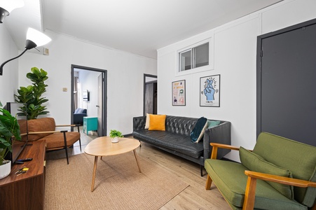 Unwind in your stylish living room featuring a plush leather sofa, vibrant accent pillows, and mid-century modern furnishings.