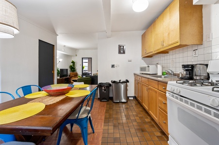 Cook memorable meals in your spacious kitchen with warm wood cabinets, full appliances, and cheerful dining table.