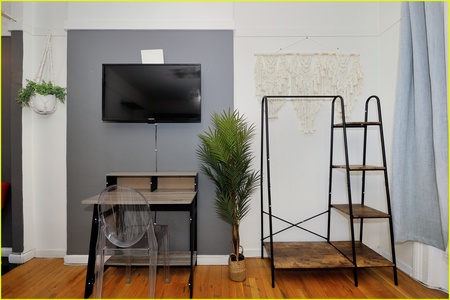 Your stylish living space features a wall-mounted TV, sleek desk, and modern decor for comfortable relaxation.