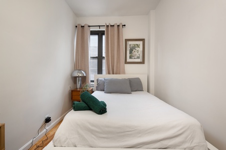 Sink into crisp white linens and plush gray pillows in your peaceful bedroom retreat, complete with thoughtful touches like fresh towels.