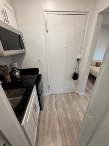 Your modern kitchen features sleek white cabinets, granite counters, and stainless steel appliances for convenient meal prep.