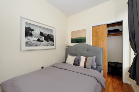 Unwind in your cozy bedroom with plush gray bedding, coastal artwork, and a convenient closet for all your belongings.