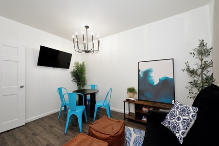 Step into your bright, modern living space where colorful blue chairs and stylish artwork create the perfect spot to unwind.