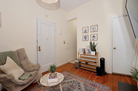 Cozy living space with warm wood floors and natural light where you can unwind in the comfortable armchair.