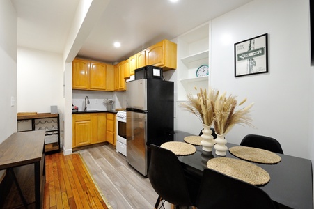 Your modern kitchen features warm wood cabinets, stainless steel appliances, and a cozy dining table perfect for home-cooked meals.