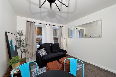 Your bright living space features a cozy navy sofa, vibrant turquoise chairs, and modern touches that create the perfect spot to unwind.