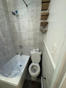 Your private bathroom features modern marble-style tiles and clever storage baskets to keep your essentials organized.