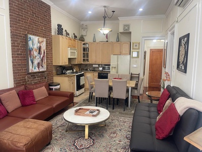 Your stylish urban retreat features exposed brick walls, comfortable leather seating, and a fully equipped kitchen perfect for cooking.
