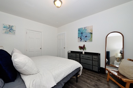 Sink into this cozy bedroom with fresh white linens, thoughtful artwork, and a peaceful atmosphere perfect for your restful getaway.
