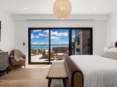 Wake up to stunning lake and mountain views from your serene bedroom, where floor-to-ceiling windows open onto your private terrace with lounge chairs and a fireplace.