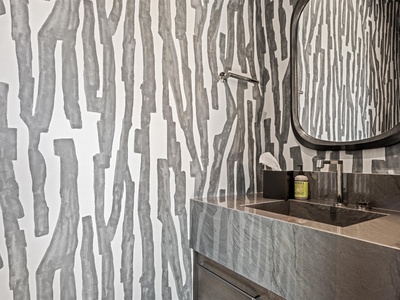 This bold, tree-inspired wallpaper brings nature indoors, creating a unique focal point that complements the sleek vanity and modern fixtures in your private bathroom.