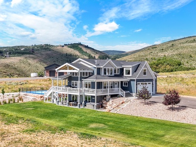 Stunning mountain estate featuring spacious decks, swimming pool, and panoramic valley views in a serene hillside setting.