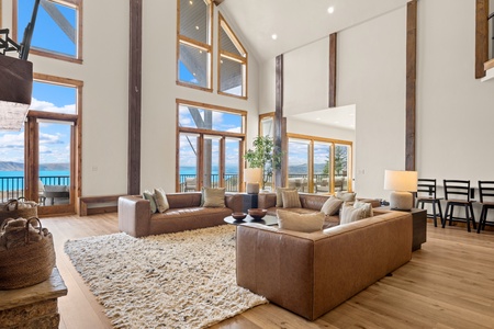 Unwind in your light-filled living space, where floor-to-ceiling windows frame breathtaking lake and mountain views, and plush leather sofas invite you to relax beneath soaring ceilings.