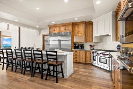 Your gourmet kitchen boasts professional-grade appliances, a spacious island with seating for ten, and stunning ocean views through the nearby windows—perfect for gathering and creating meals together.