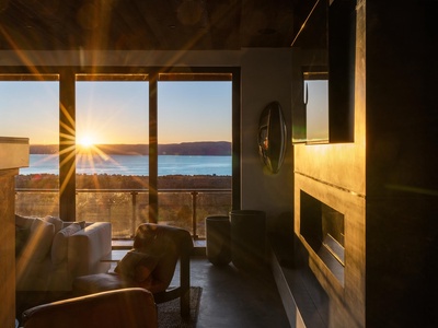 Watch golden sunbeams spill across your living space as the sun sets over tranquil lake waters—your front-row seat to nature's nightly show, framed by modern comfort and warmth.