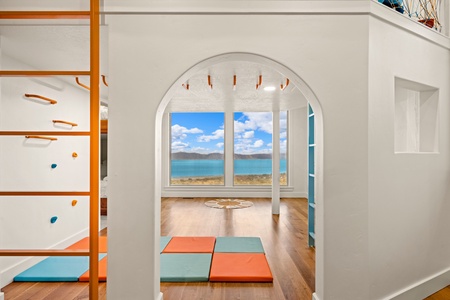 A peaceful indoor play space with colorful mats where your little ones can explore and play safely while taking in the serene lake views beyond.