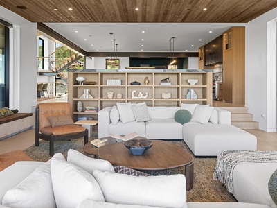 Sink into plush seating in your open-concept living space, where natural wood accents and thoughtful design create a warm, sophisticated retreat for relaxing together.