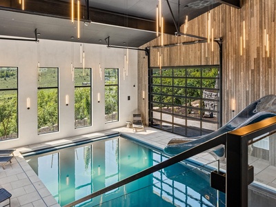 Step inside your private indoor pool sanctuary, where floor-to-ceiling windows frame lush garden views and warm wood tones create a serene, spa-like escape—perfect for unwinding year-round.