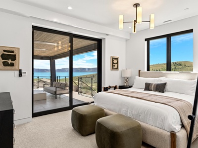 Wake up to stunning lake and mountain views from your serene bedroom, where modern comfort meets natural beauty through floor-to-ceiling windows opening to your private balcony.